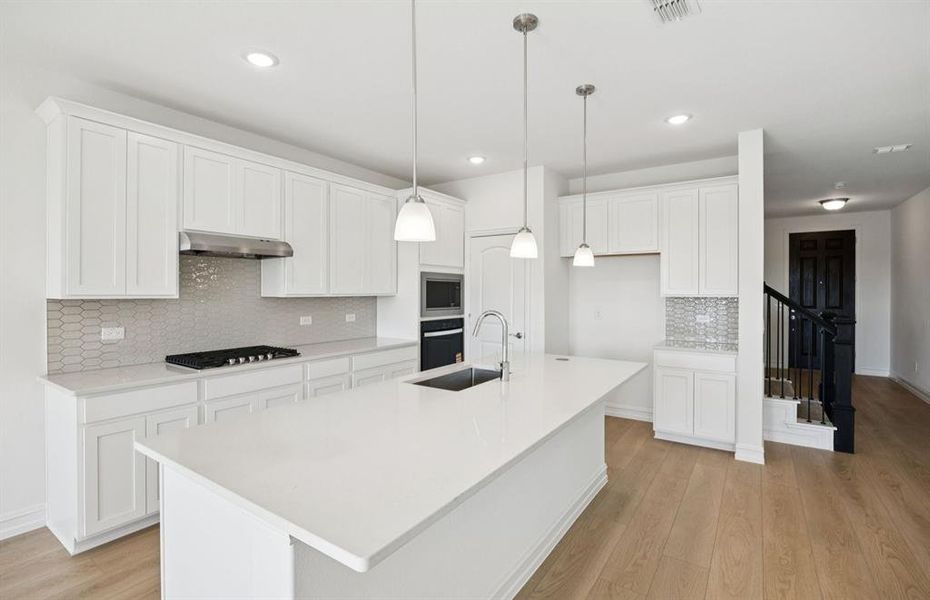 Large island overlooking gathering room and dining areas