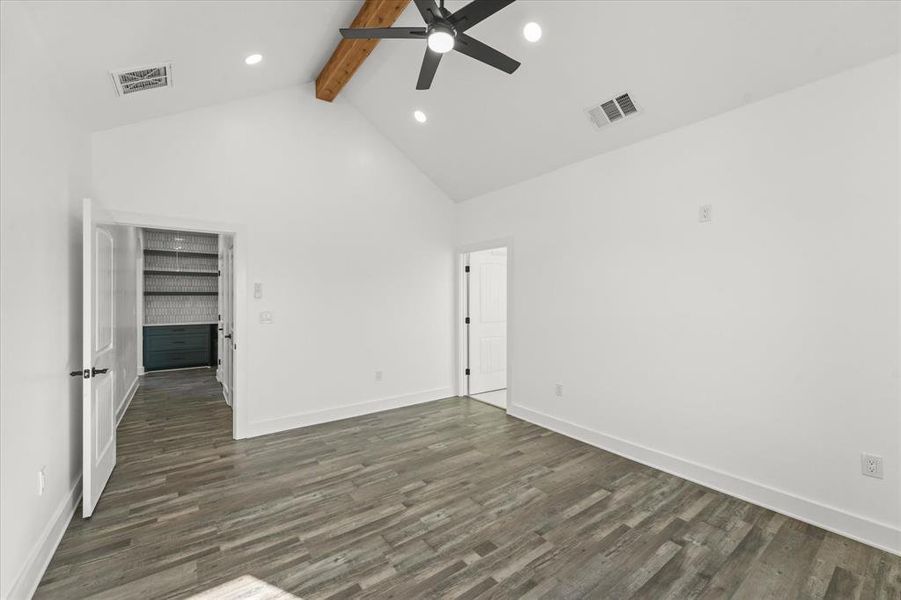 Unfurnished room featuring beam ceiling, high vaulted ceiling, dark hardwood / wood-style floors, and ceiling fan