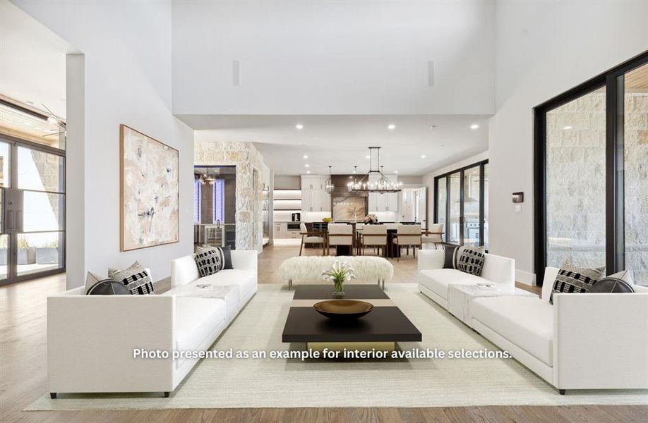 Living room featuring a healthy amount of sunlight, a notable chandelier, and light hardwood / wood-style floors