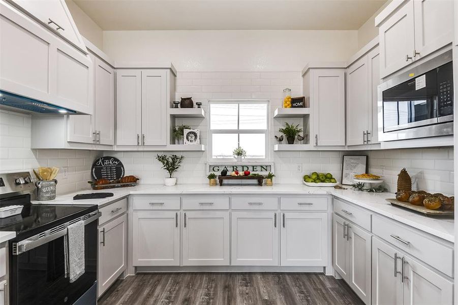 Kitchen featuring open shelves, appliances with stainless steel finishes, white cabinetry, and decorative backsplash