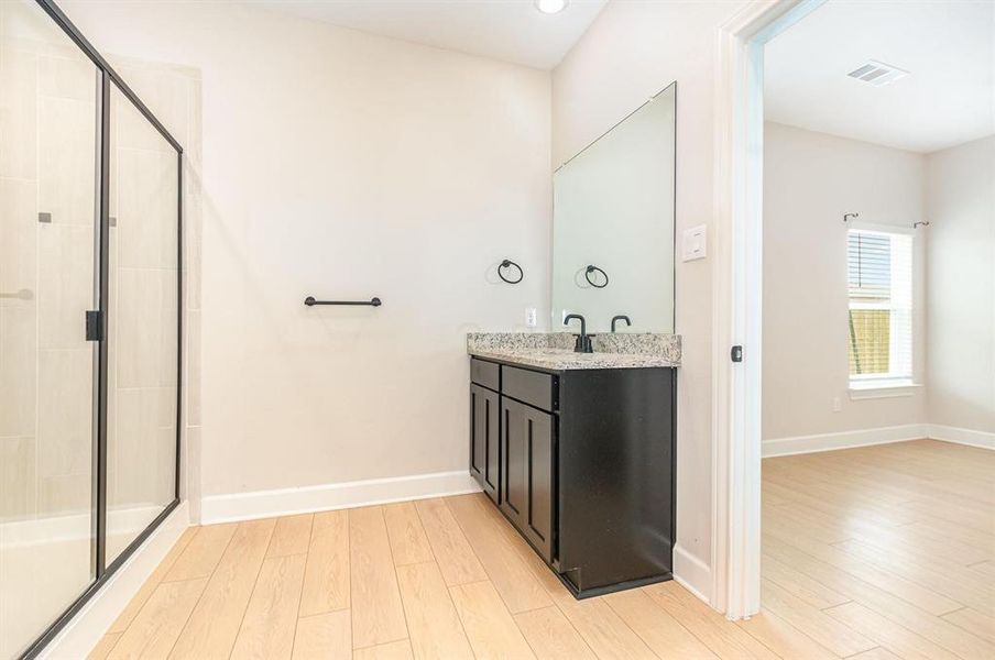 Full bath with light wood-style floors, vanity, a shower stall, and recessed lighting Full bath with light wood-style floors, vanity, a shower stall, and recessed lighting