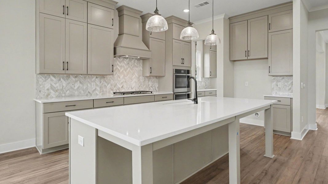 Kitchen with quartz countertops, pendant lighting, and tile backsplash