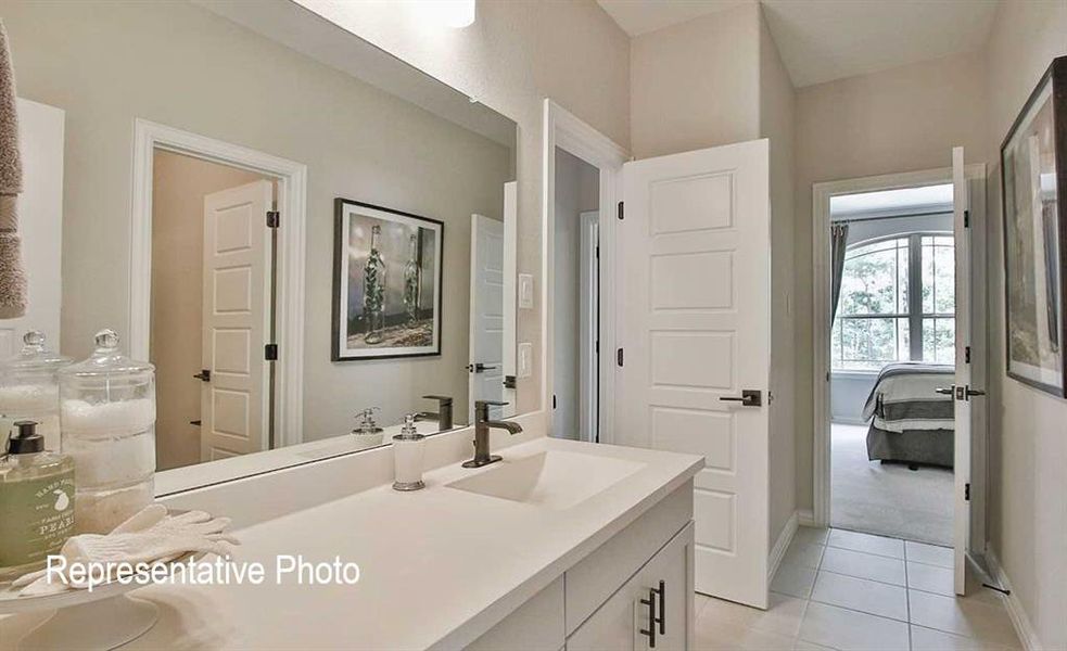 Bathroom featuring tile flooring and vanity with extensive cabinet space