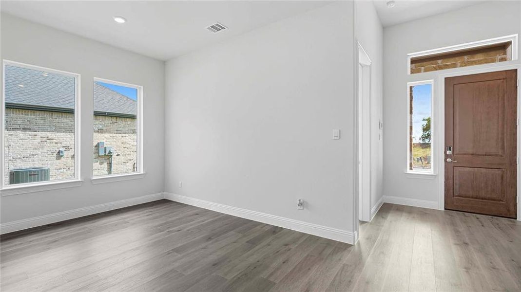 Entryway featuring a wood-finish door with sidelight and transom, light gray wood-finish flooring, recessed lighting, and white baseboards