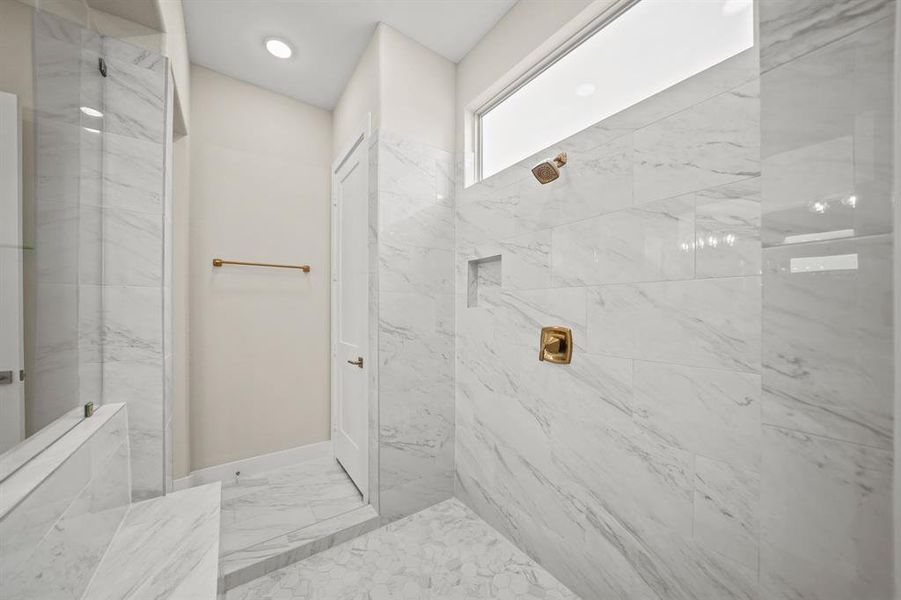 Beautiful walk-in shower with gorgeous tile walls, and recessed lighting.