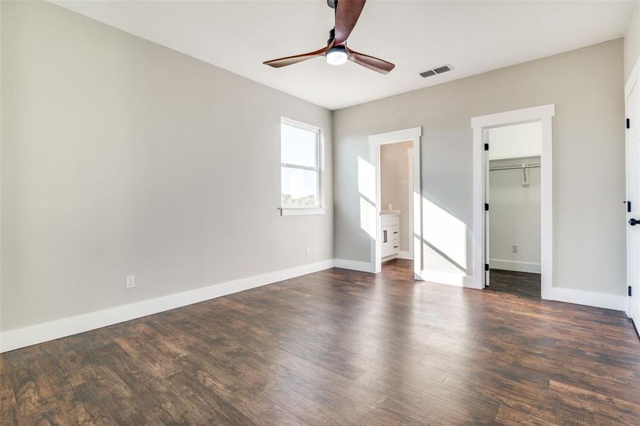 Empty room featuring ceiling fan and dark hardwood / wood-style floors