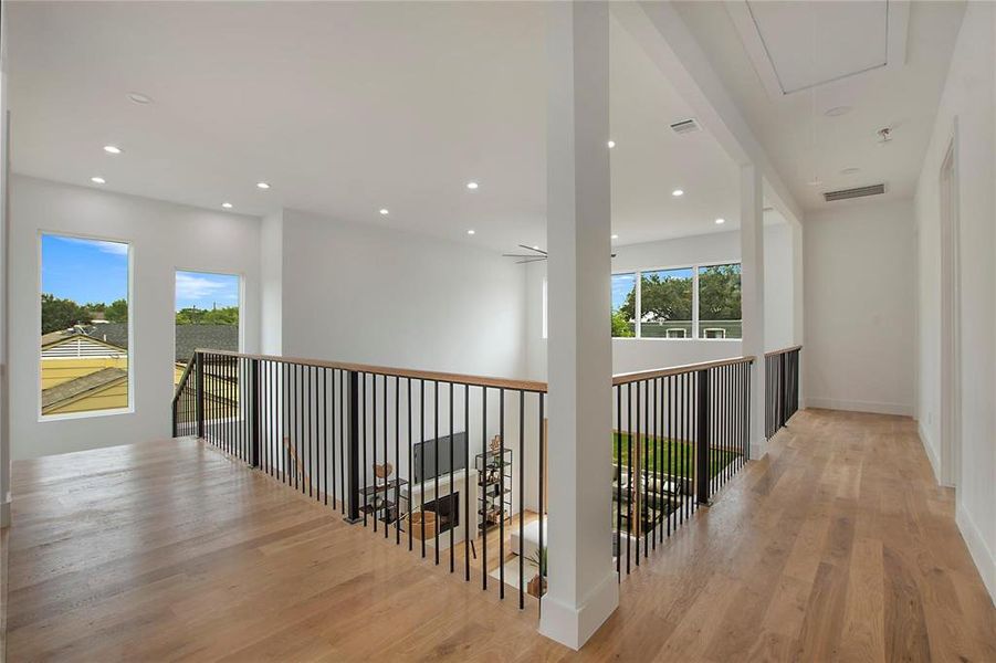 Hall featuring attic access, healthy amount of natural light, light wood-type flooring, recessed lighting, and baseboards Hall featuring attic access, healthy amount of natural light, light wood-type flooring, recessed lighting, and baseboards