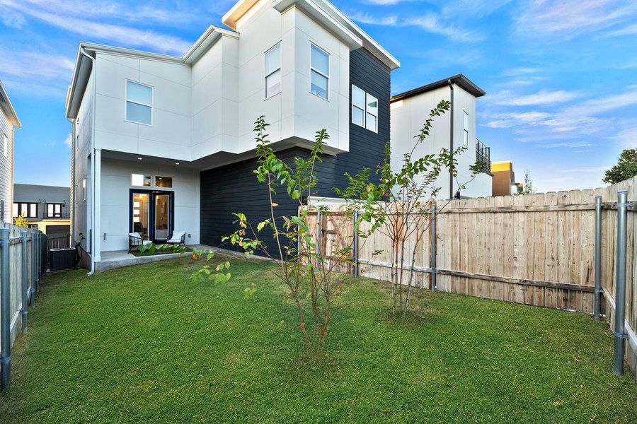 Back of house with a fenced backyard and a patio area