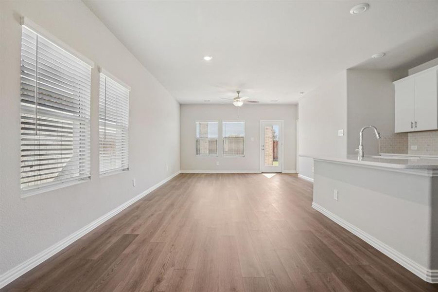 Unfurnished living room with dark wood finished floors, a ceiling fan, and recessed lighting