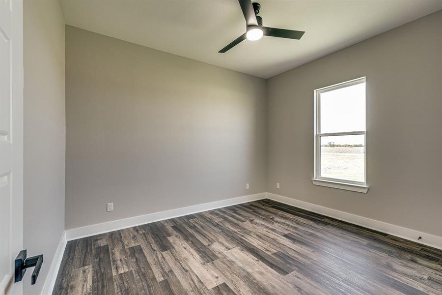 Empty room with dark hardwood / wood-style floors and ceiling fan