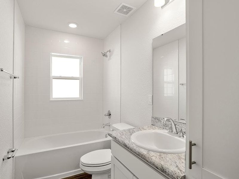 Secondary bedrooms share a convenience hall bath with linen cabinets.