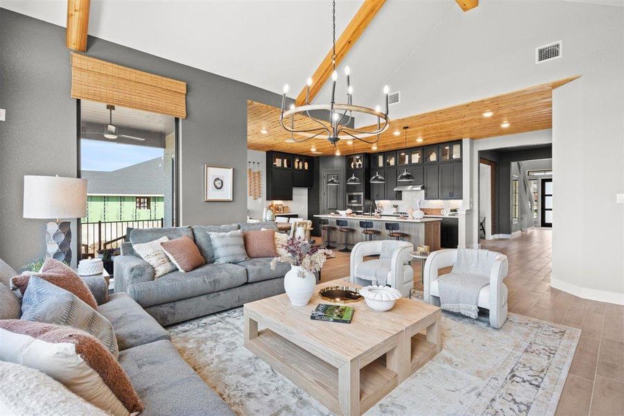 Living area featuring suspended lighting, vaulted ceiling, and light wood-style floors