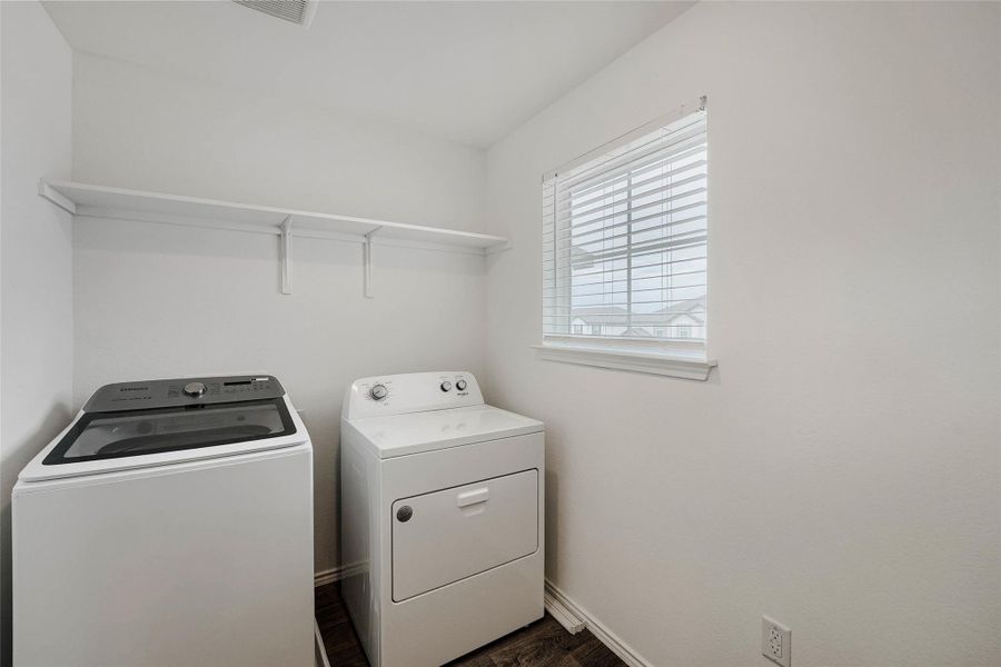 Upstairs Laundry area featuring overhead shelving, a window with blinds, and wood-finish flooring Upstairs Laundry area featuring overhead shelving, a window with blinds, and wood-finish flooring