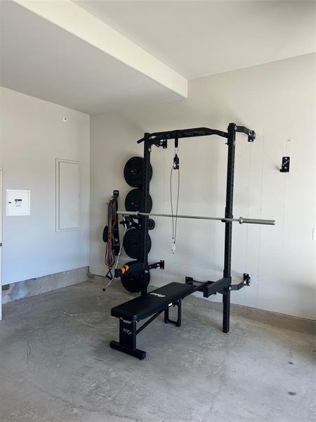 2 car garage with door opener and retractable workout weight station that can convey to the new buyer - View