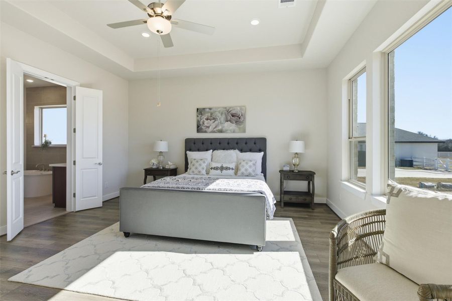 Bedroom with a raised ceiling, wood finished floors, a ceiling fan, and recessed lighting