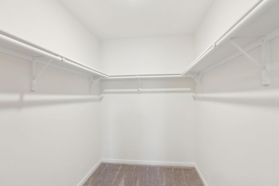 The spacious primary walk-in closet offers an abundance of storage with integrated built-in shelving, providing a perfectly organized retreat.