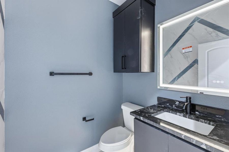 Half bath featuring vanity and toilet