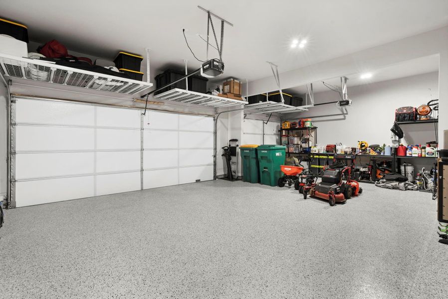 Oversized garage with epoxy flooring and overhead shelving Oversized garage with epoxy flooring and overhead shelving