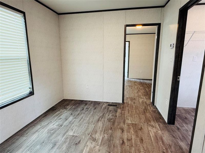 Empty room with wood finished floors and crown molding