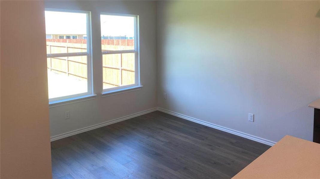 Unfurnished room with dark wood-style floors and baseboards