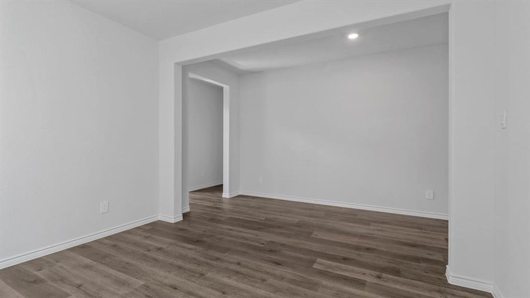Spare room with dark wood-type flooring and baseboards