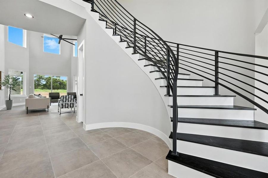 Stairway featuring ceiling fan, a high ceiling, and recessed lighting