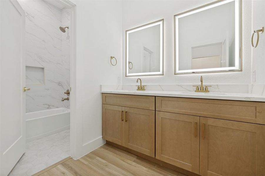 Dual vanity featuring light wood-finish cabinetry and white countertops Dual vanity featuring light wood-finish cabinetry and white countertops