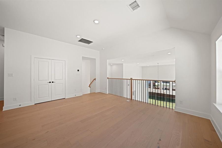 Empty room featuring recessed lighting, light wood-style flooring, and a chandelier Empty room featuring recessed lighting, light wood-style flooring, and a chandelier