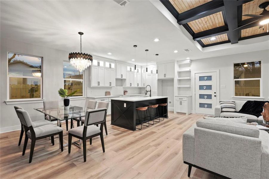 Dining room with light wood finished floors, beamed ceiling, and hanging lights Dining room with light wood finished floors, beamed ceiling, and hanging lights