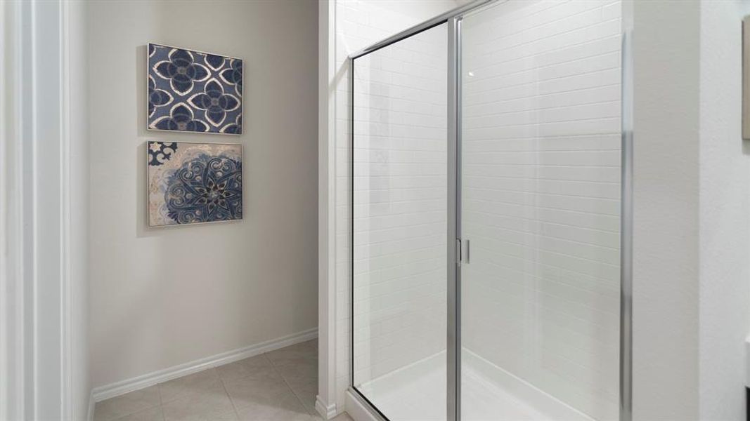 Bathroom with a stall shower and light tile patterned flooring