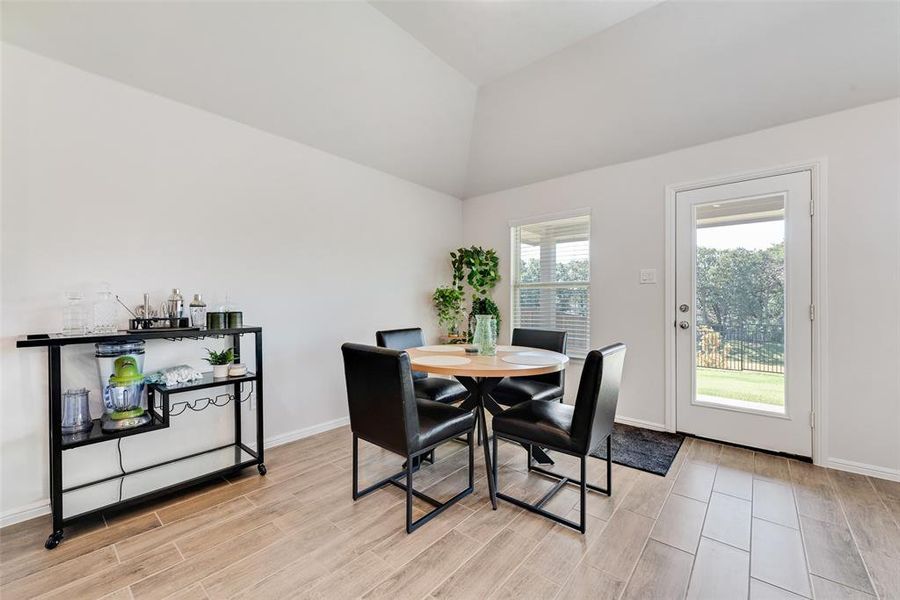 Dining area with wood tiled floors and lofted ceiling Dining area with wood tiled floors and lofted ceiling