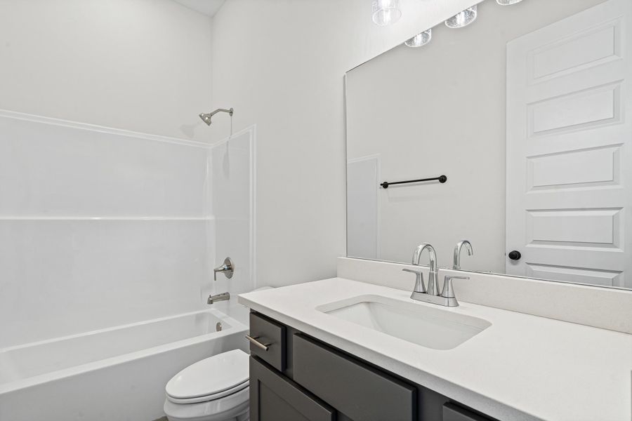 White bathroom featuring a dark wood-finish vanity with a white countertop and undermount sink White bathroom featuring a dark wood-finish vanity with a white countertop and undermount sink