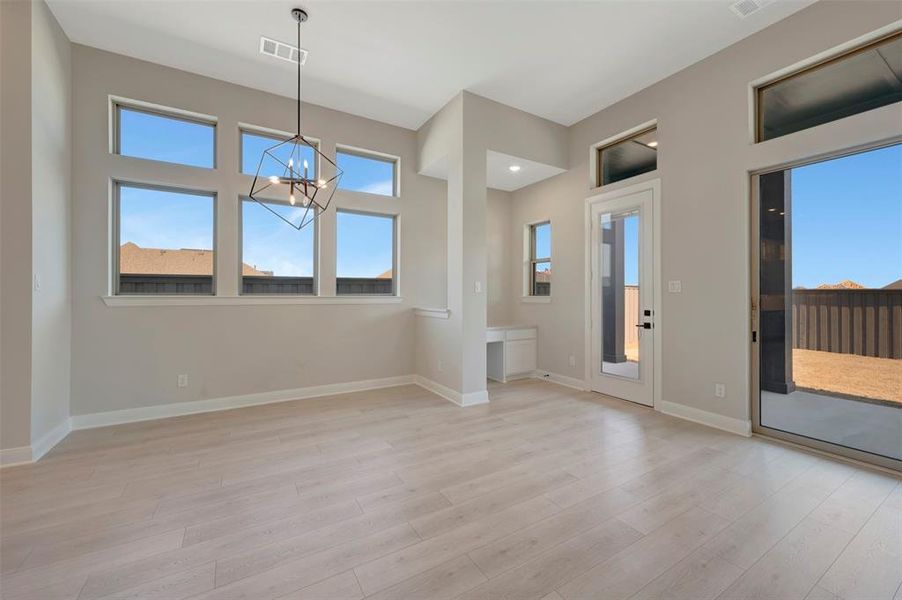Unfurnished dining area featuring light wood-style floors and suspended lighting Unfurnished dining area featuring light wood-style floors and suspended lighting