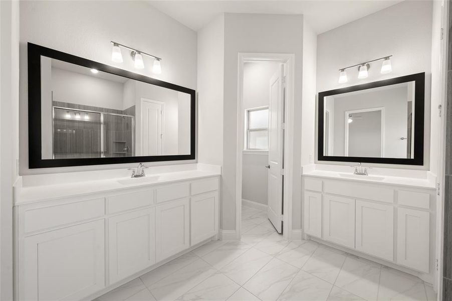 Bathroom with two vanities, a stall shower, and light marble finish flooring