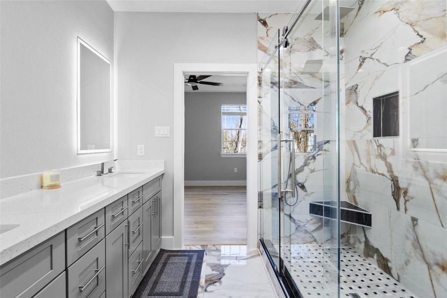 This angle shows how thoughtfully designed your space really is—dual vanities with generous counter space, modern cabinetry, and integrated lighting that’s both functional and flattering. It’s bright, calm, and designed for real everyday use without sacrificing style.