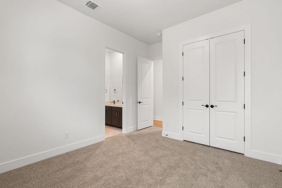 A quiet bedroom with serene relaxation and easy access to a private bath.