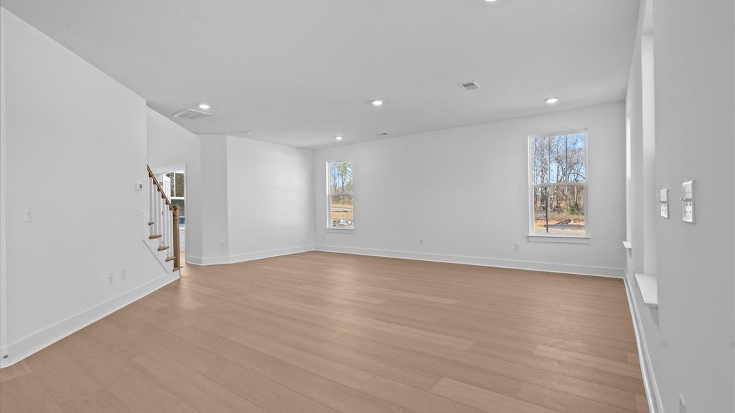 Spacious family room with rich hardwood flooring and elegant trim work in a reputable DRB Homes build