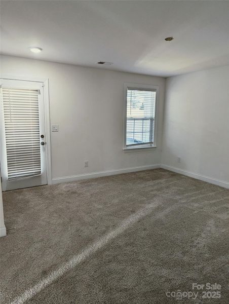 Main level bdrm w/en suite full bath, 2 walk-in closets, door leading to covered patio