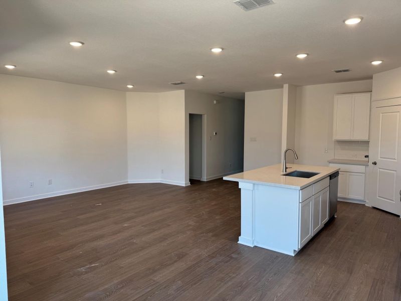 Kitchen with recessed lighting, dark wood finished floors, white cabinetry, an island with sink, and open floor plan Kitchen with recessed lighting, dark wood finished floors, white cabinetry, an island with sink, and open floor plan