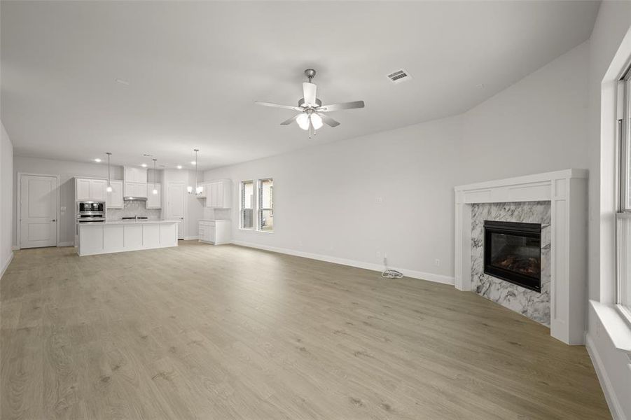 Unfurnished living room with a fireplace, recessed lighting, light wood-style floors, and a ceiling fan
