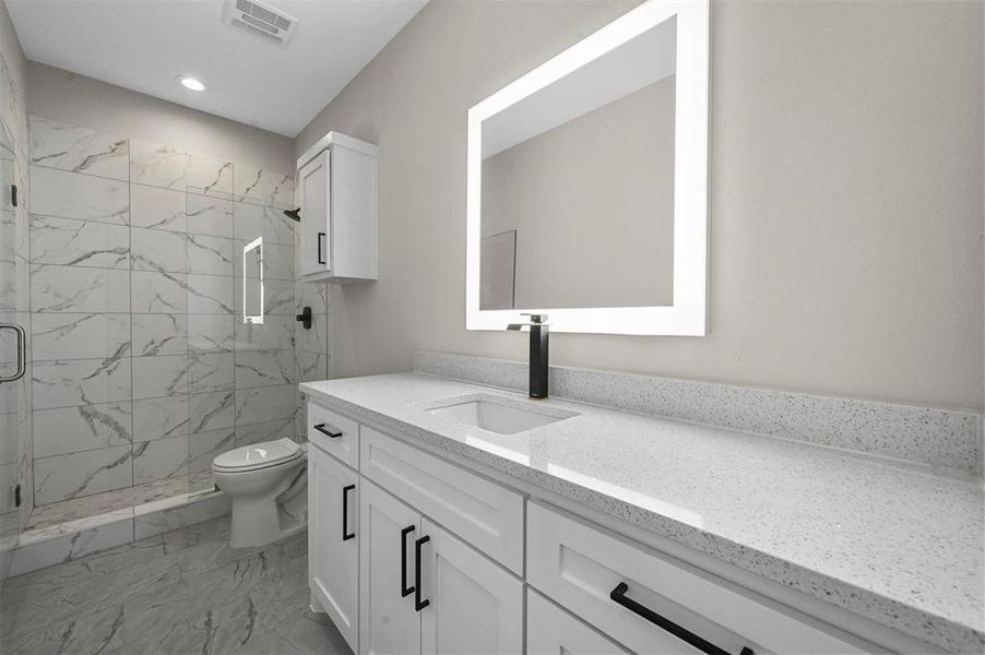 Bathroom with vanity, tile patterned floors, toilet, and an enclosed shower