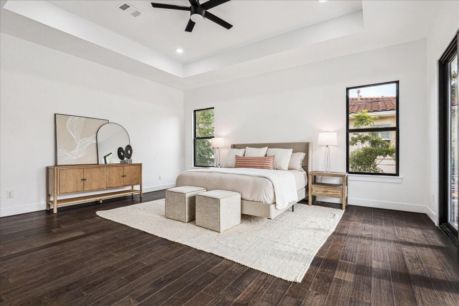 This view captures the room’s elegant trayed ceiling and the light that streams through, creating a bright, airy, and serene retreat.