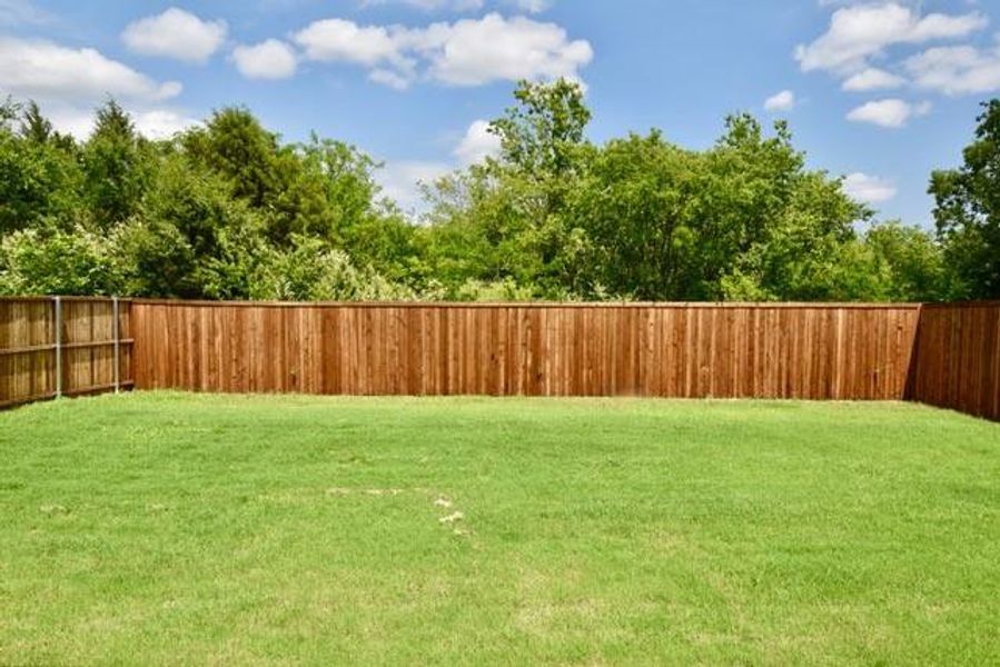 View of spacious fenced backyard