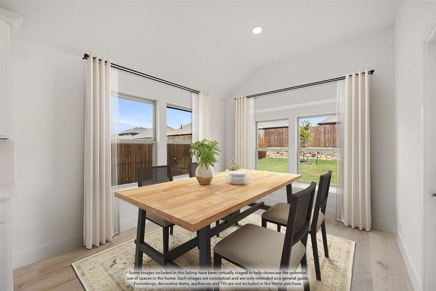 Dining room with wood table, four chairs, vaulted ceiling, and large windows overlooking backyard