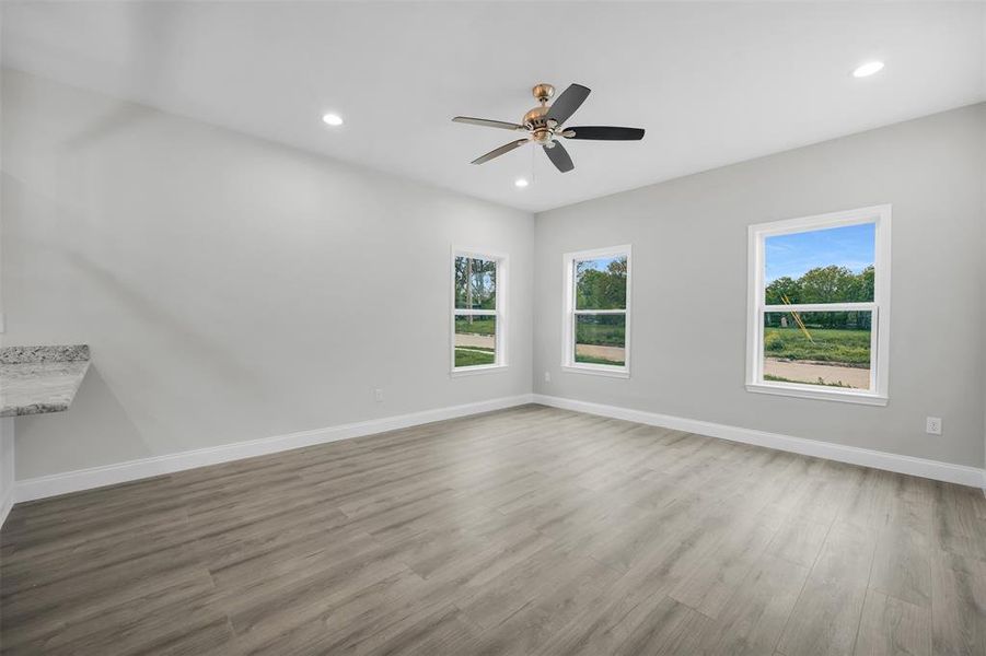 Empty room featuring recessed lighting, baseboards, a ceiling fan, and wood finished floors Empty room featuring recessed lighting, baseboards, a ceiling fan, and wood finished floors