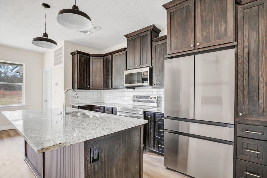 These cabinets are gorgeous and what about those drawers! Drop lighting over the bar - looks like 3 barstools will pull up nicely for snacks and chatting with the chef!