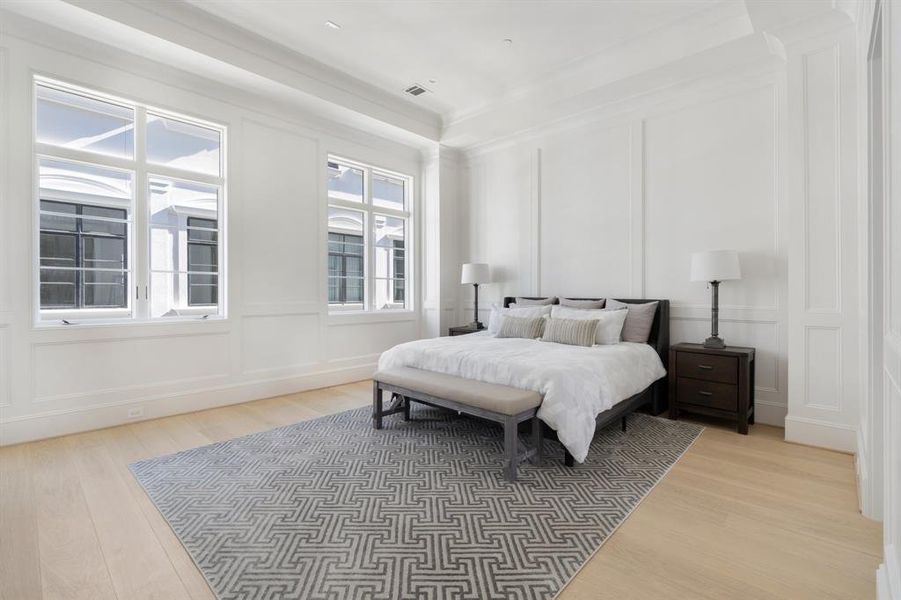 The luxurious master bedroom boasts soaring 12' tray ceiling with elegant floor to ceiling paneling. (photo of interior model home with smaller floor plan)