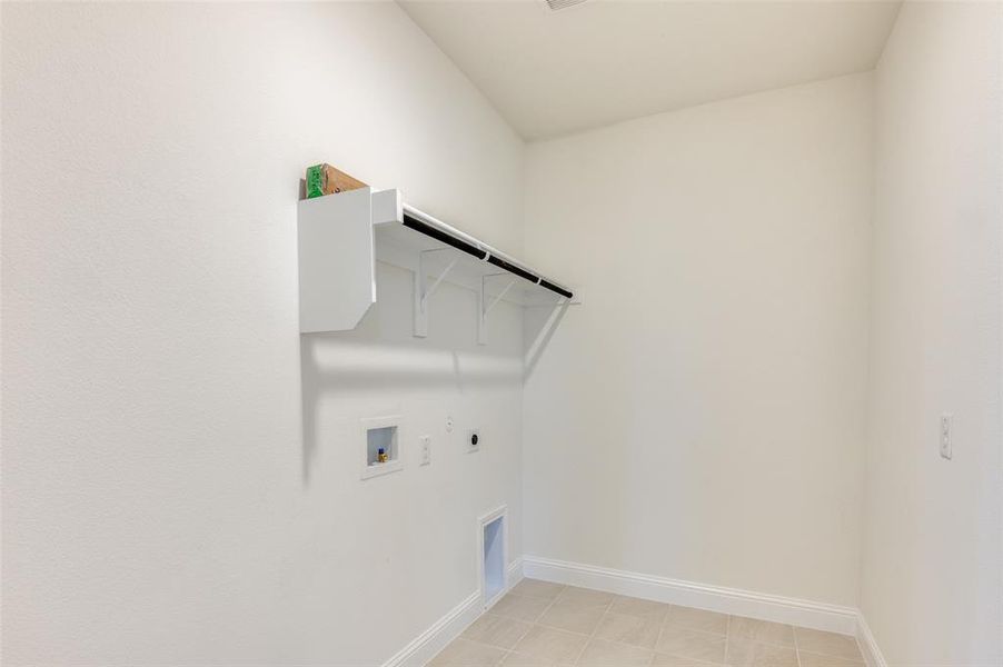 Laundry room with gas dryer hookup, hookup for an electric dryer, washer hookup, and light tile patterned floors