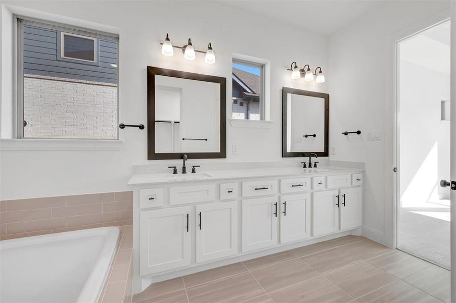 Dual vanity featuring white cabinetry, integrated sinks, and dark framed mirrors Dual vanity featuring white cabinetry, integrated sinks, and dark framed mirrors