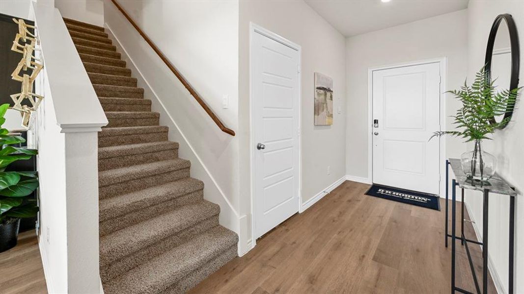 Foyer entrance featuring wood finished floors and stairway